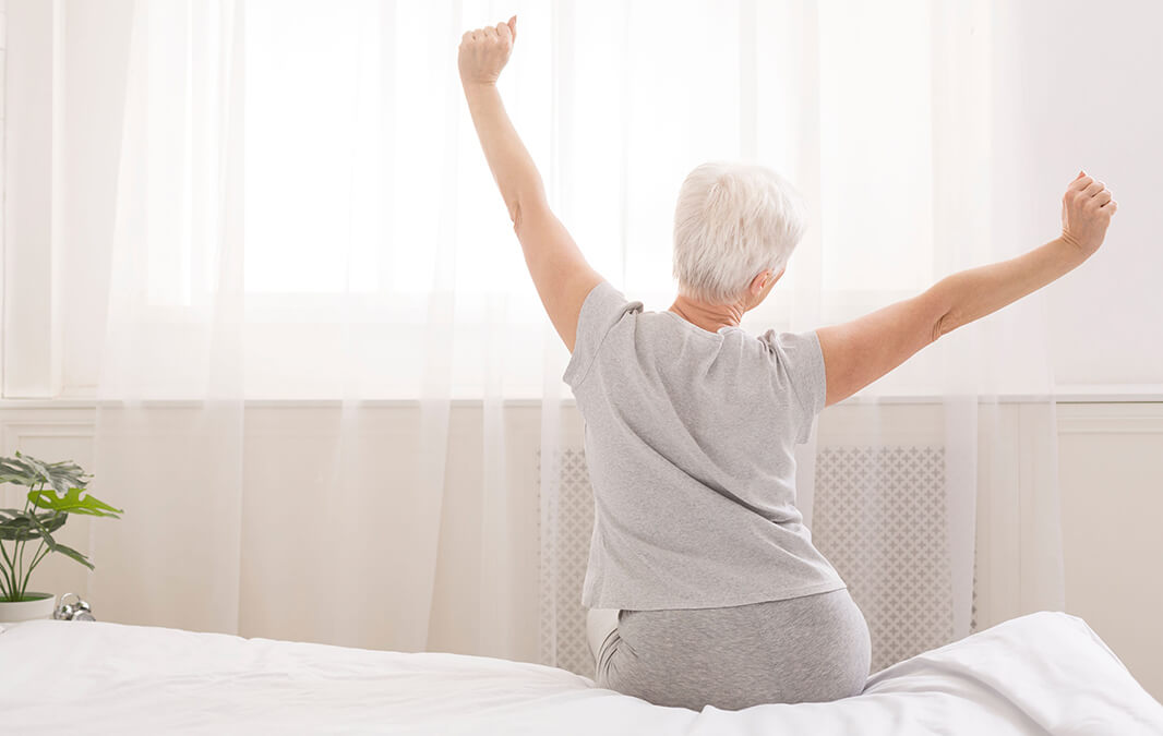 Elderly woman stretching on the bed